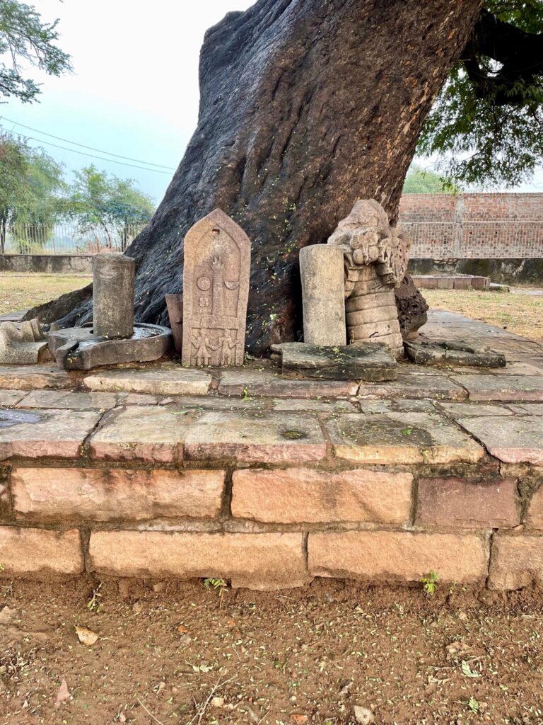 Some remains of a temple which existed nearby during the times can be seen reclining against trees.
