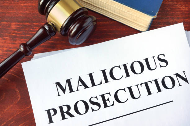 Malicious prosecution and gavel on a table.